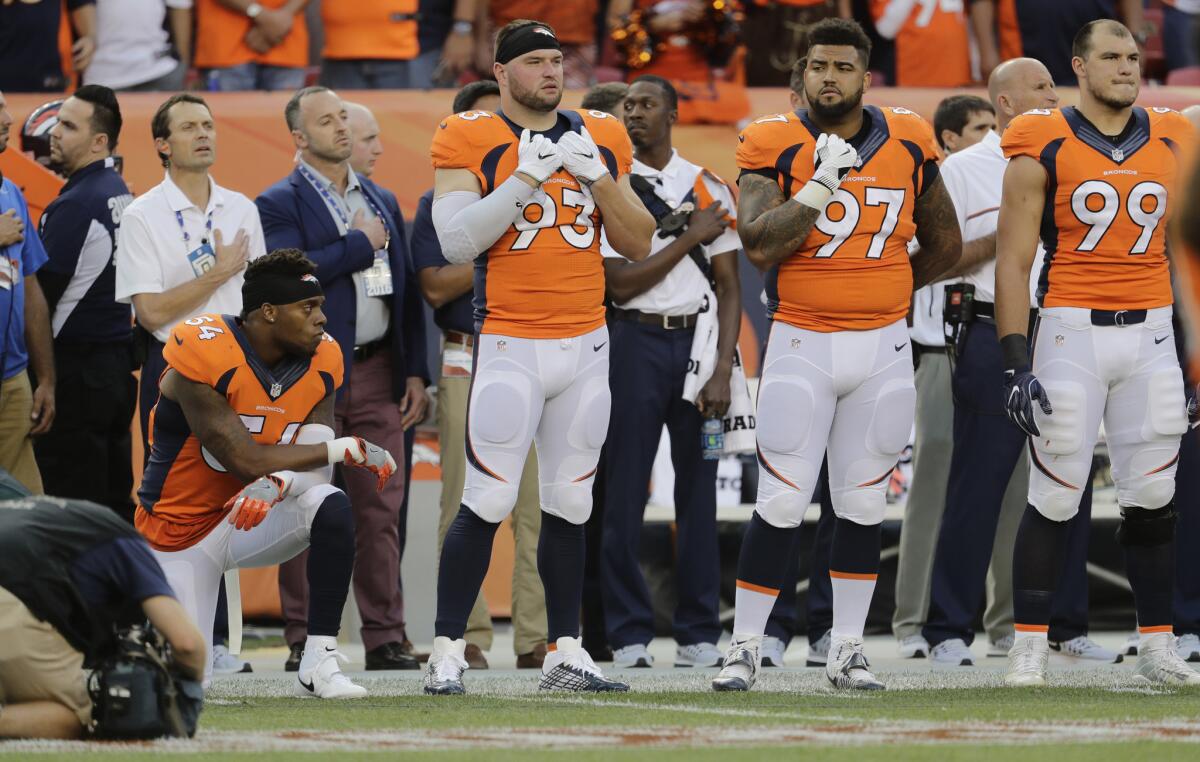 Broncos inside linebacker Brandon Marshall (54) kneels on the sideline during the national anthem prior to a game against the Carolina Panthers.