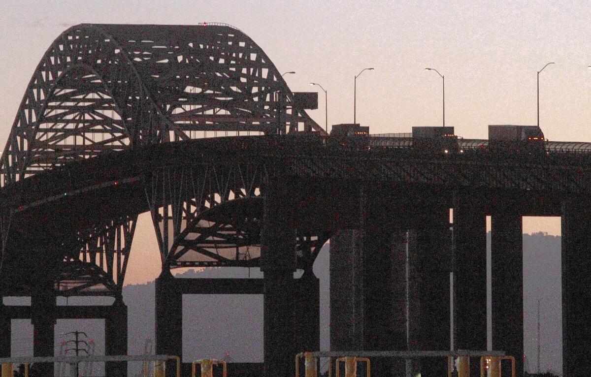 Three trucks cross the Gerald Desmond Bridge in Long Beach. A string of actions by state officials and the National Labor Relations Board has strengthened the hand of truck drivers who say they need union representation to improve pay and working conditions.