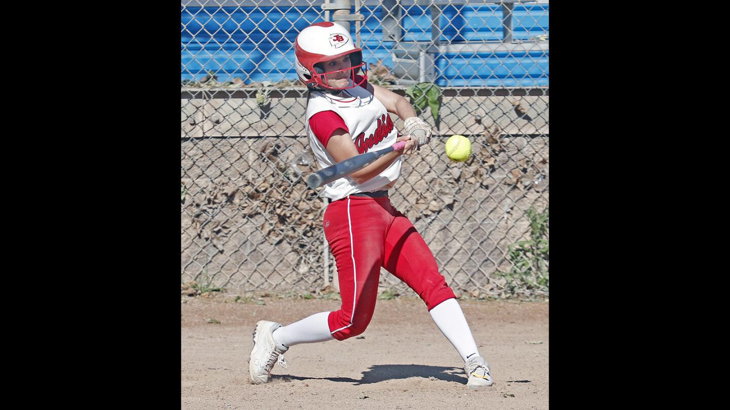 Burroughs' Nikki Ricciardella hits a two-run double against Glendale at Olive Park softball field in Burbank on Tuesday, March 27, 2018. Burroughs won the game by mercy.