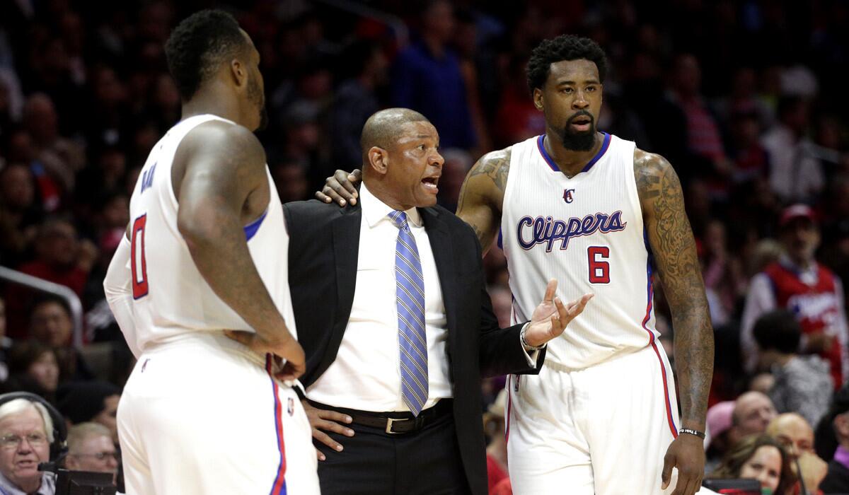 Clippers head coach Doc Rivers, center, talks to DeAndre Jordan, right, and Glen Davis during the Clippers' 90-87 loss to the Memphis Grizzlies on Monday.