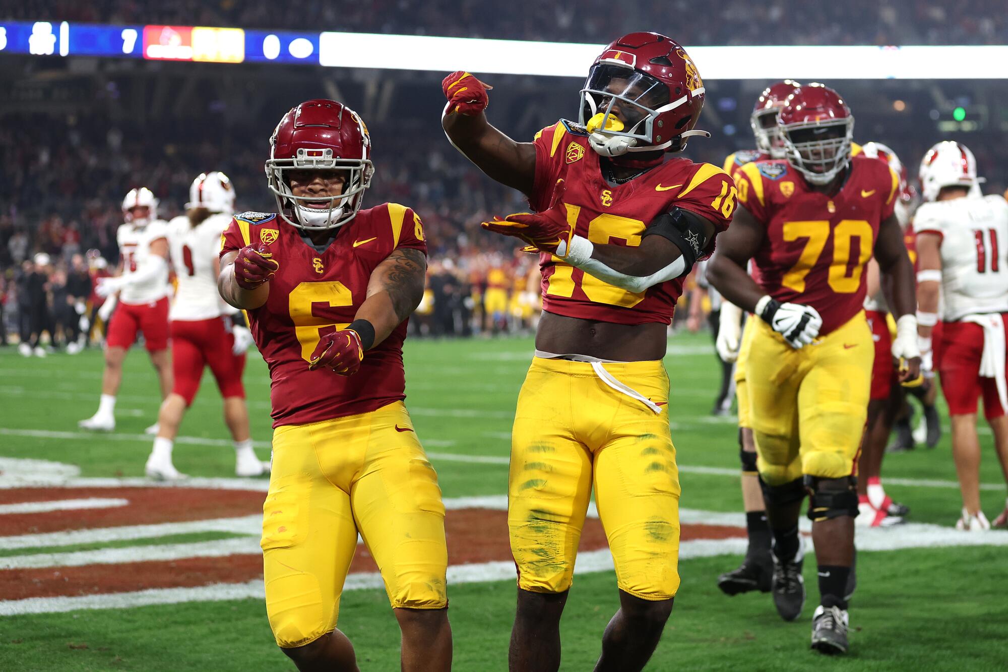 USC's Austin Jones and Tahj Washington celebrate after scoring a touchdown against Louisville