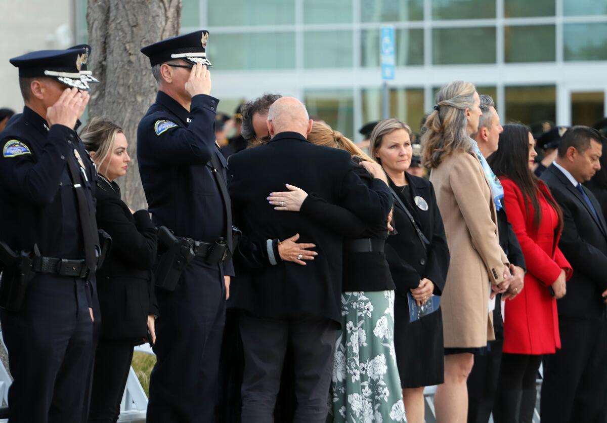 The family of the late Huntington Beach Police Officer Nicholas Vella hug one another at a ceremony last week.