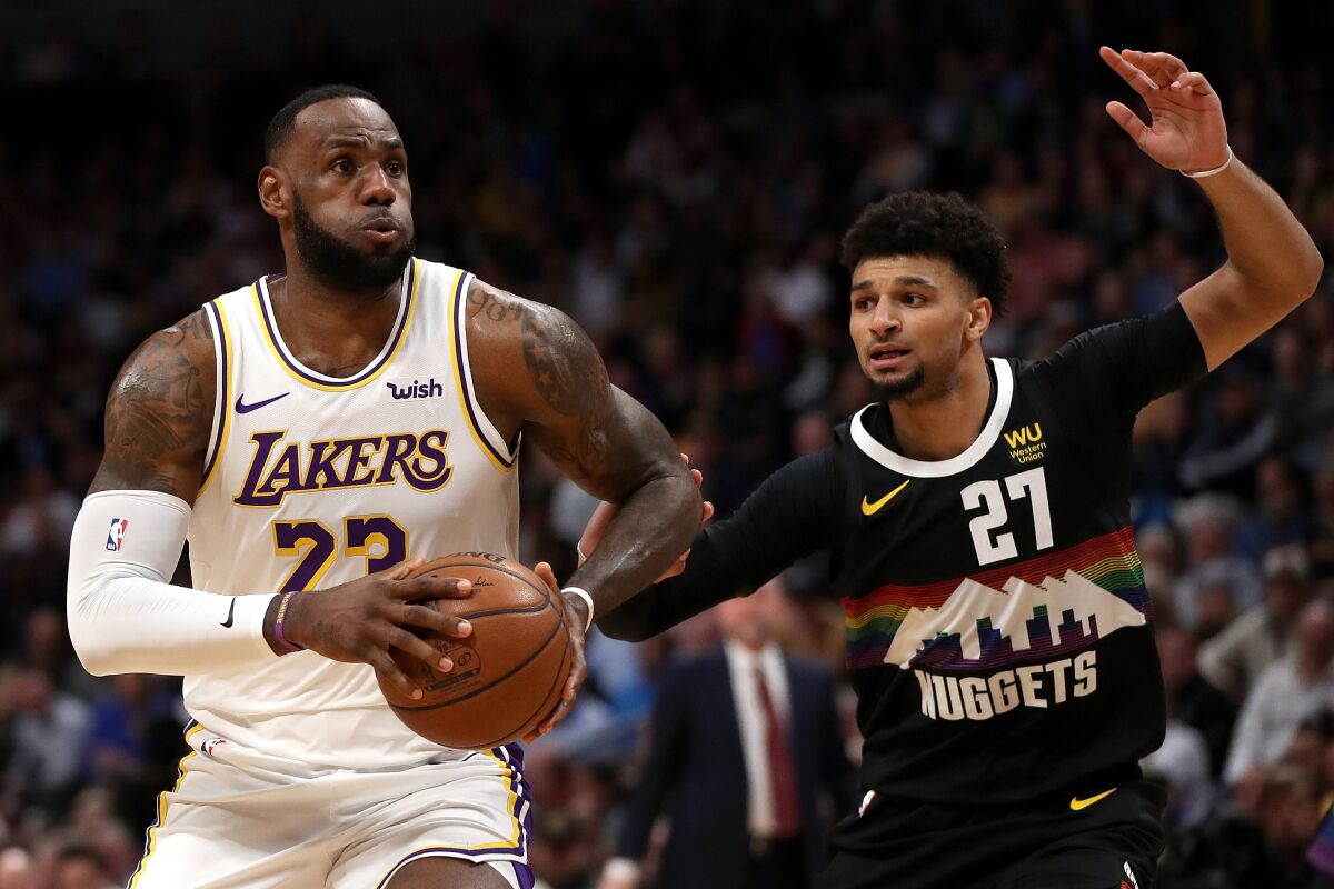 Lakers' Lebron James (23) drives against Denver Nuggets' Jamal Murray (27) in the first quarter on Tuesday in Denver.