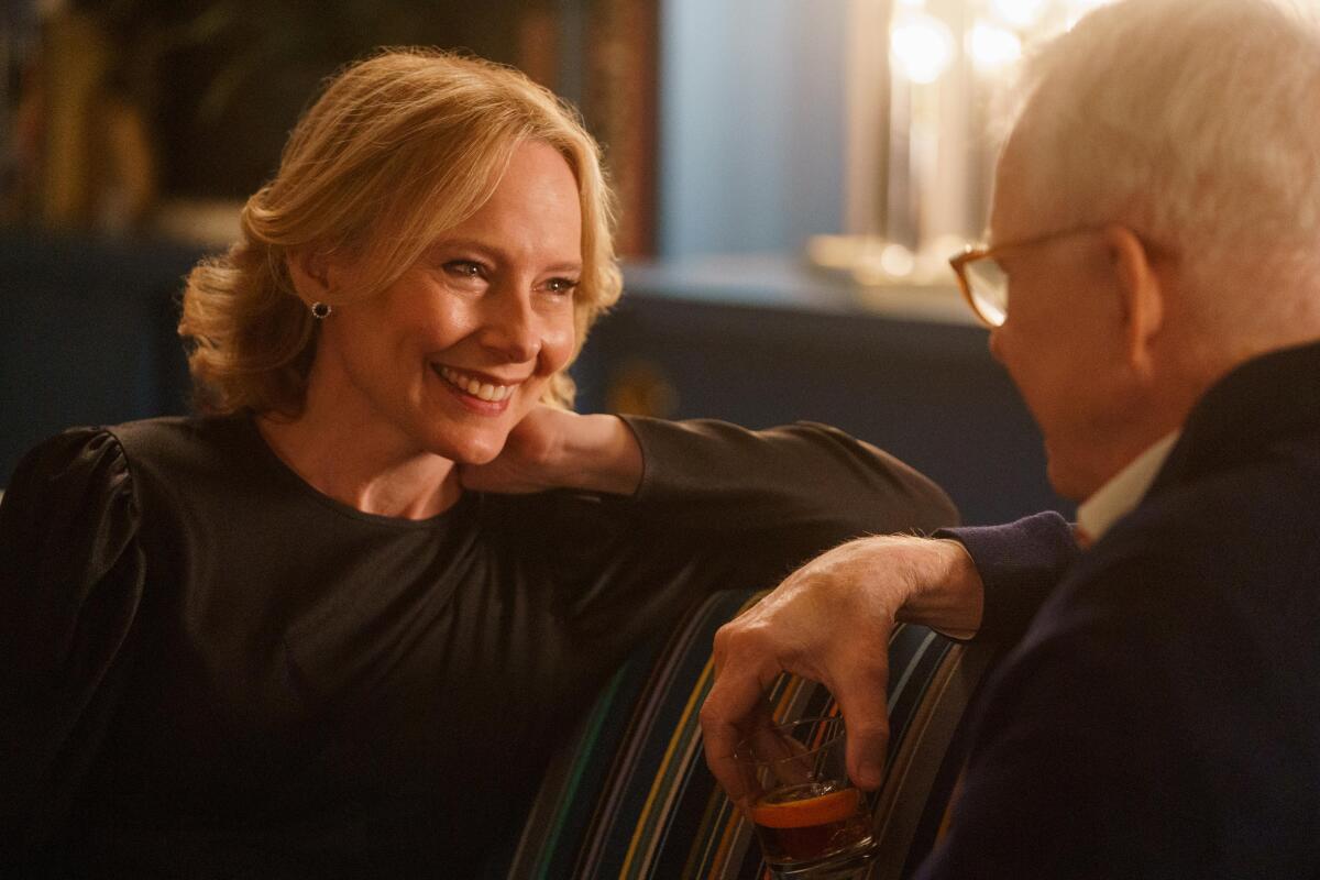A woman smiles at a man sitting across from her