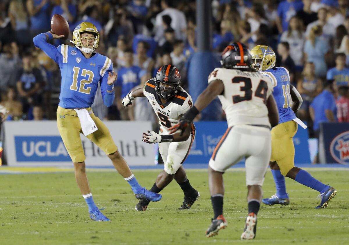 UCLA quarterback Austin Burton (12) runs out of the pocket against Oregon State during the first half Saturday at the Rose Bowl.