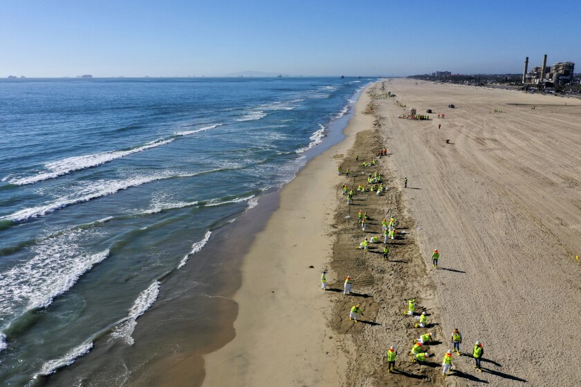 Workers clean up an oil spill at Huntington State Beach.