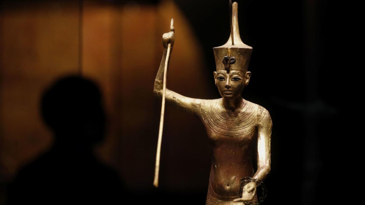 A gilded wooden figure of Tutankhamun on a skiff in "King Tut: Treasures of the Golden Pharoah."