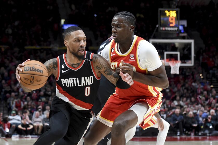 Portland Trail Blazers guard Damian Lillard, left, drives to the basket on Atlanta Hawks center Clint Capela, right, during the second half of an NBA basketball game in Portland, Ore., Monday, Jan. 30, 2023. The Blazers won 129-125. (AP Photo/Steve Dykes)