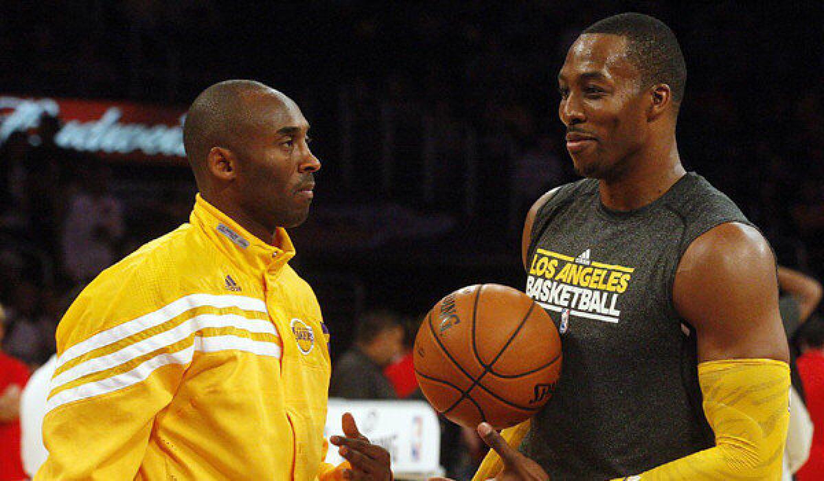 Lakers superstars Kobe Bryant, left, and Dwight Howard chat before a preseason game against the Sacramento Kings on Sunday.