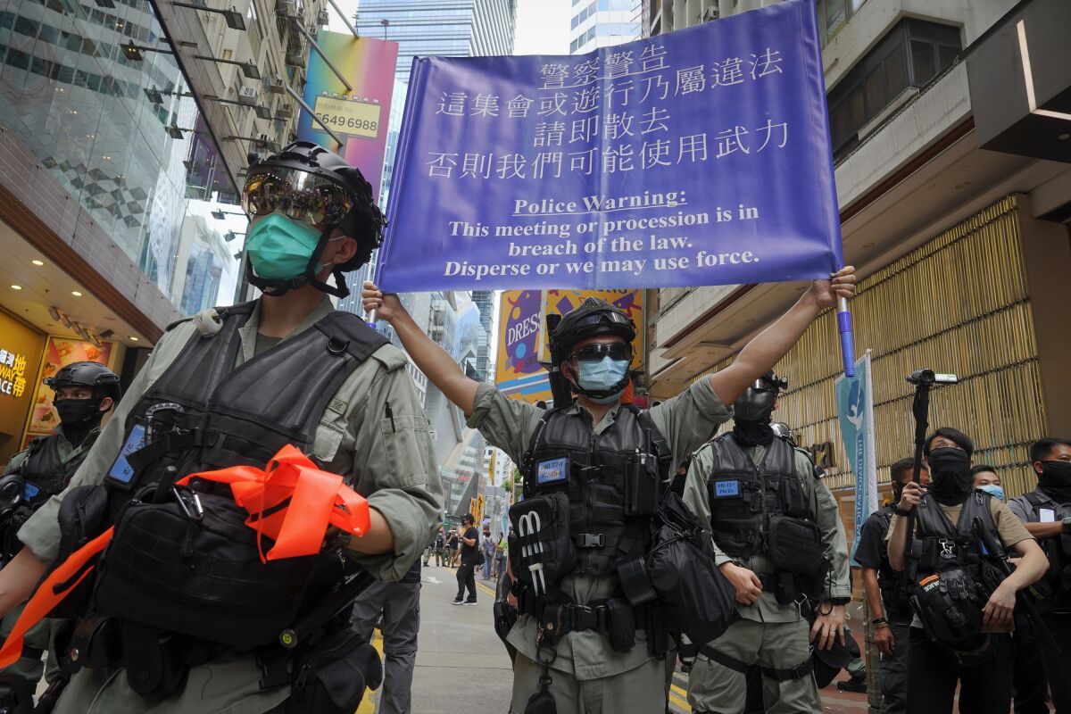 Police display a banner at a march on the 23rd anniversary of Hong Kong's handover to China