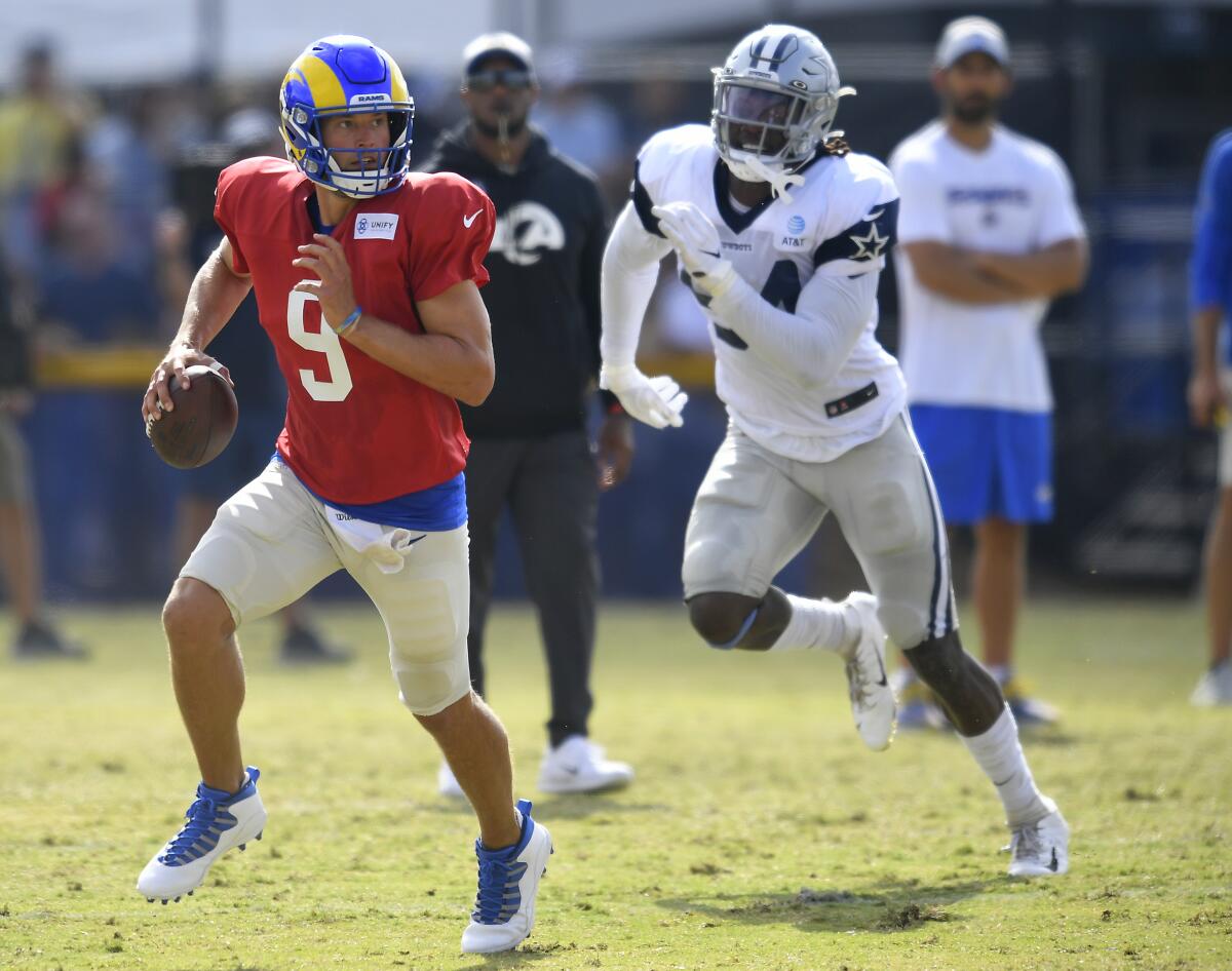 Rams quarterback Matthew Stafford scrambles away from Cowboys defensive end Randy Gregory on Aug. 7, 2021.
