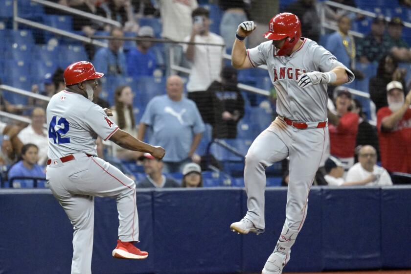 Los Angeles Angels' Mike Trout, right, celebrates with third base coach Eric Young Sr.