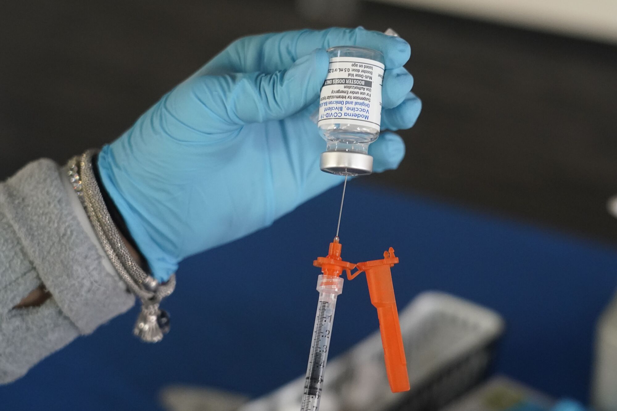 A Jackson-Hinds Comprehensive Health Center nurse loads a syringe with a Moderna COVID-19 booster