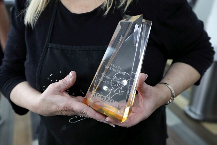 Gladys Olmeda holds the prestigious Kerazon, a hair salon of the year award, in the Hairsculptor.com salon in Costa Mesa.