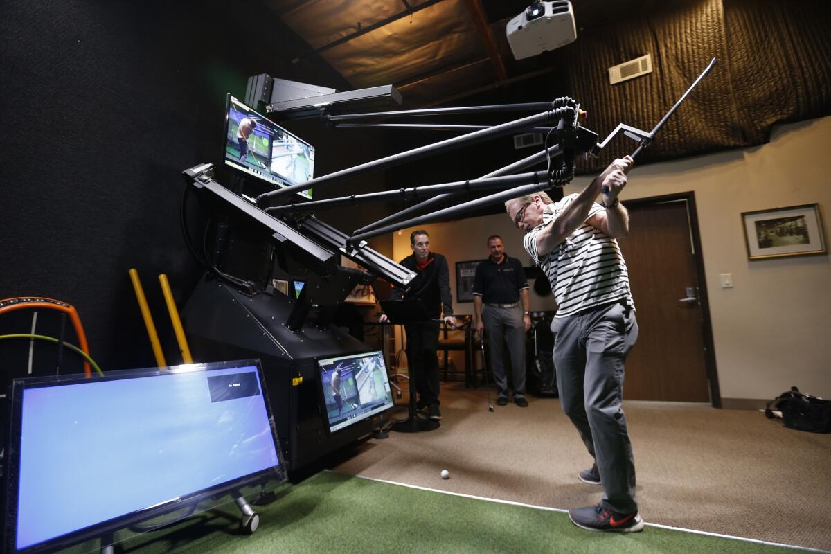 Times columnist Chris Erskine works on improving his golf swing with the Robogolfpro at So Cal Golf in Irvine on March 11.