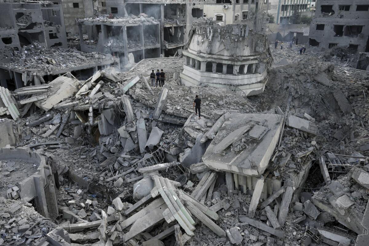 Palestinos revisan los escombros de la mezquita Yassin, la cual fue destruida por un ataque aéreo israelí.