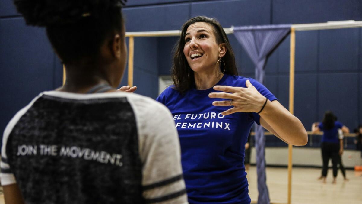 Urban Latin dance theater company director Ana Maria Alvarez expresses the dance movements to Jasmine Stanley during rehearsal.