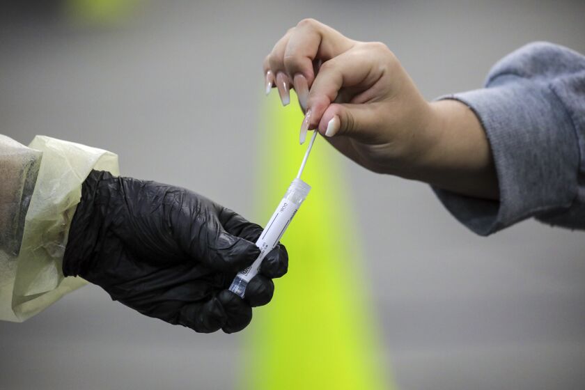 Rancho Cucamonga, CA - December 30: A nasal swab is being collected at COVID19 testing site established by San Bernardino County Department of Health at Rancho Cucamonga Sports Center on Thursday, Dec. 30, 2021 in Rancho Cucamonga, CA. (Irfan Khan / Los Angeles Times)