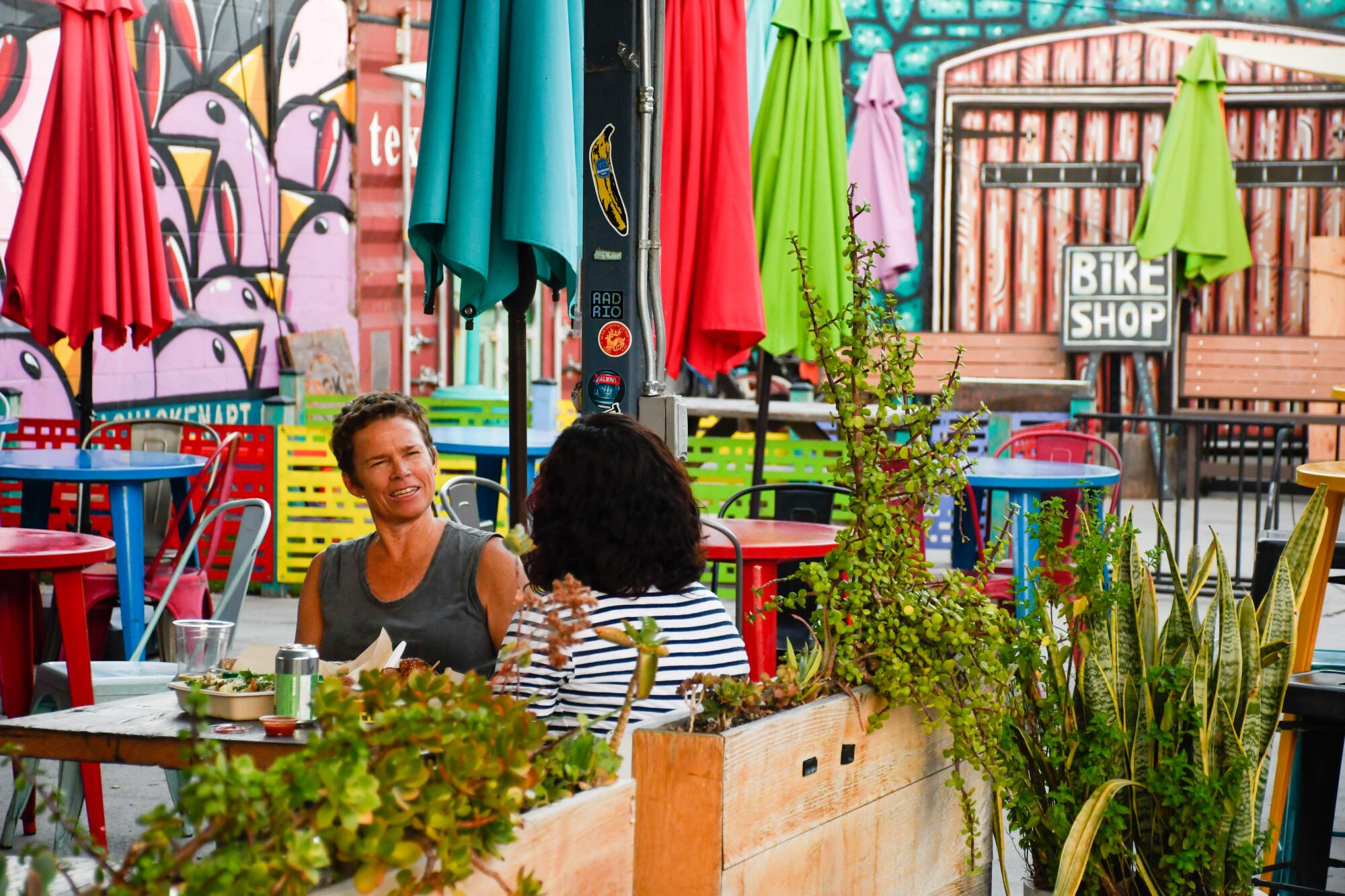 Two people sitting at an outdoor table at Spoke Bicycle Cafe.