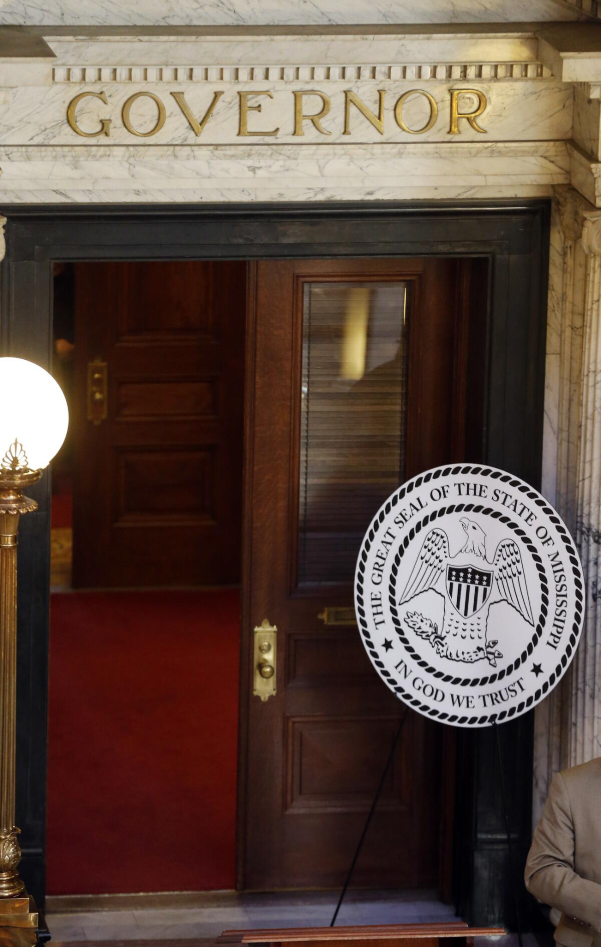 A mockup of the suggested new Mississippi state seal, with the words "In God we trust" added, sits outside Gov. Phil Bryant's office at the state Capitol in Jackson. The change is one of several parts of a controversial "religious freedom restoration" measure awaiting action by the governor.