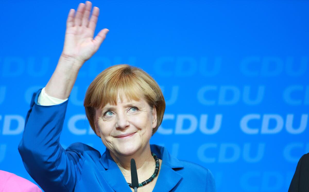 German Chancellor Angela Merkel waves to supporters at the Christian Democratic party's headquarters in Berlin on Sunday. An exit poll indicates that she won a third term as Germany's leader.