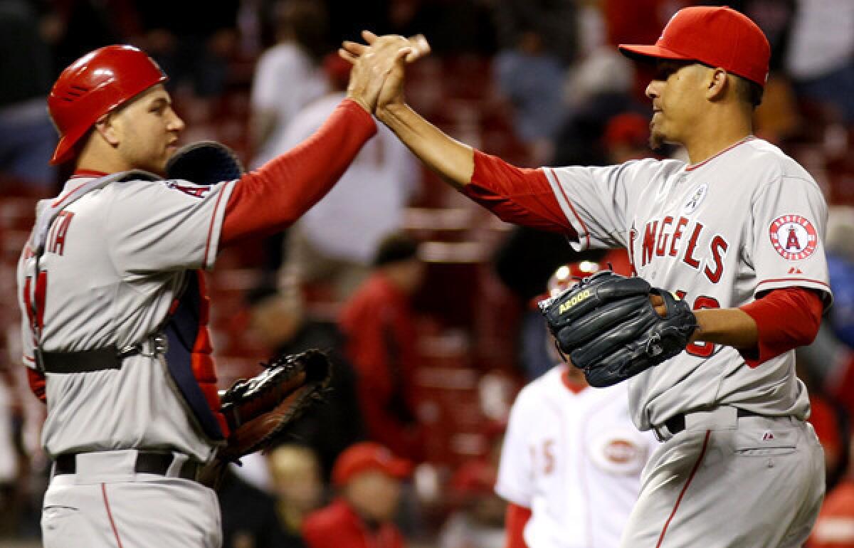 Angels catcher Chris Iannetta congratulates closer Ernesto Frieri after a 3-1 victory over the Reds in 13 innings on Monday in Cincinnati.