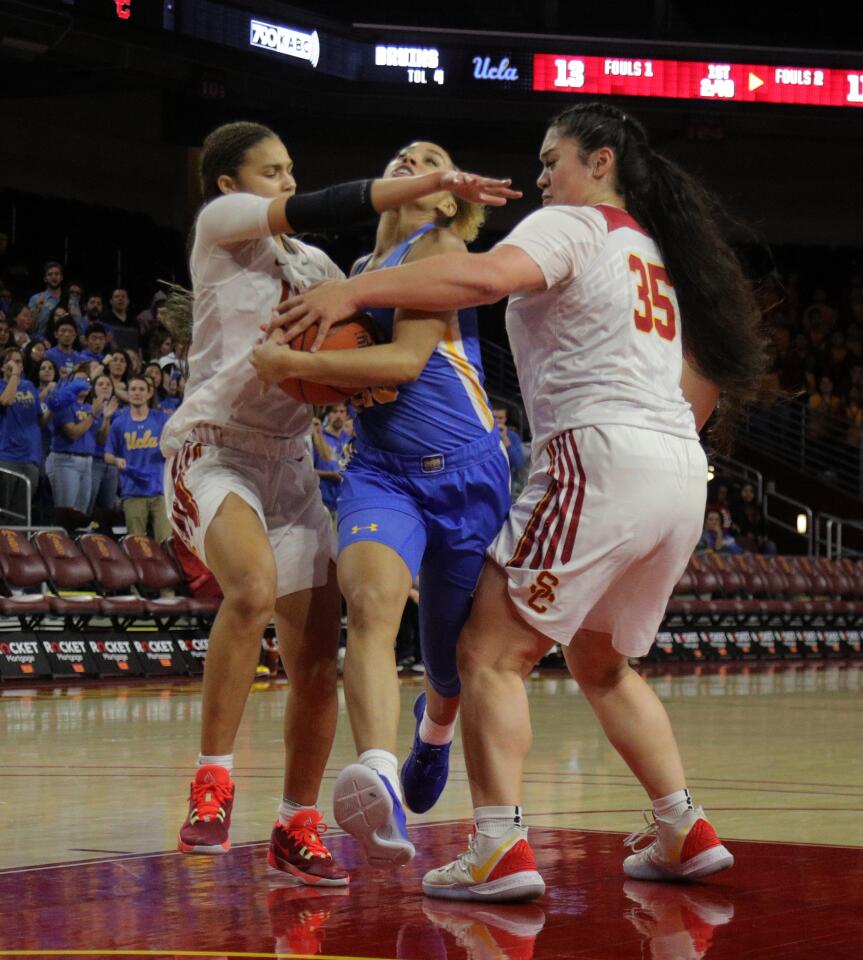 USC guard Endyia Rogers (4) and forward Alissa Pili (35) double-team UCLA guard Jaden Owens (13) during the first half of a game Jan. 17 at Galen Center.