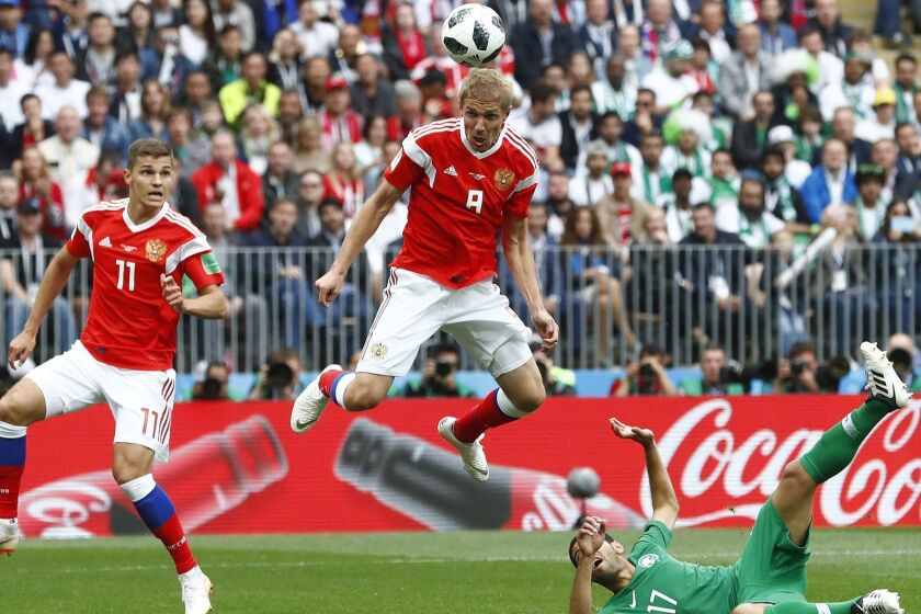 Russia's Yuri Gazinsky heads the ball to score the opening goal during the group A match between Russia and Saudi Arabia which opens the 2018 soccer World Cup at the Luzhniki stadium in Moscow, Russia, Thursday, June 14, 2018. (AP Photo/Matthias Schrader)
