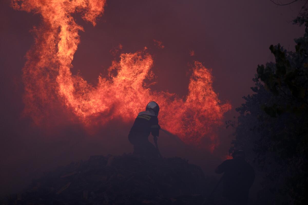 A firefighter battles towering flames