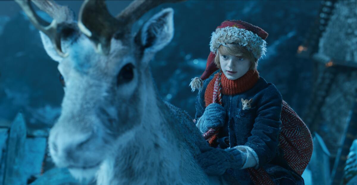 A boy in a Santa hat rides a reindeer in "A Boy Called Christmas"