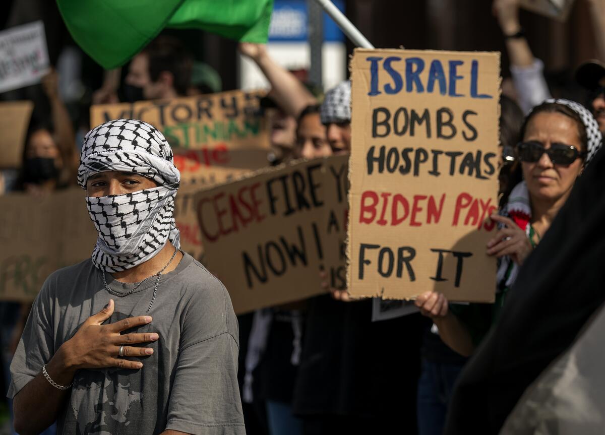 Protesters hold signs.