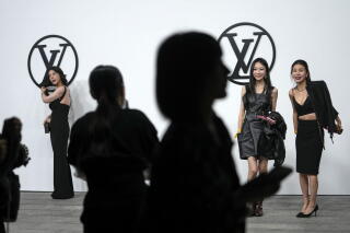 Invited guests take souvenir photos after attending the Louis Vuitton Wom