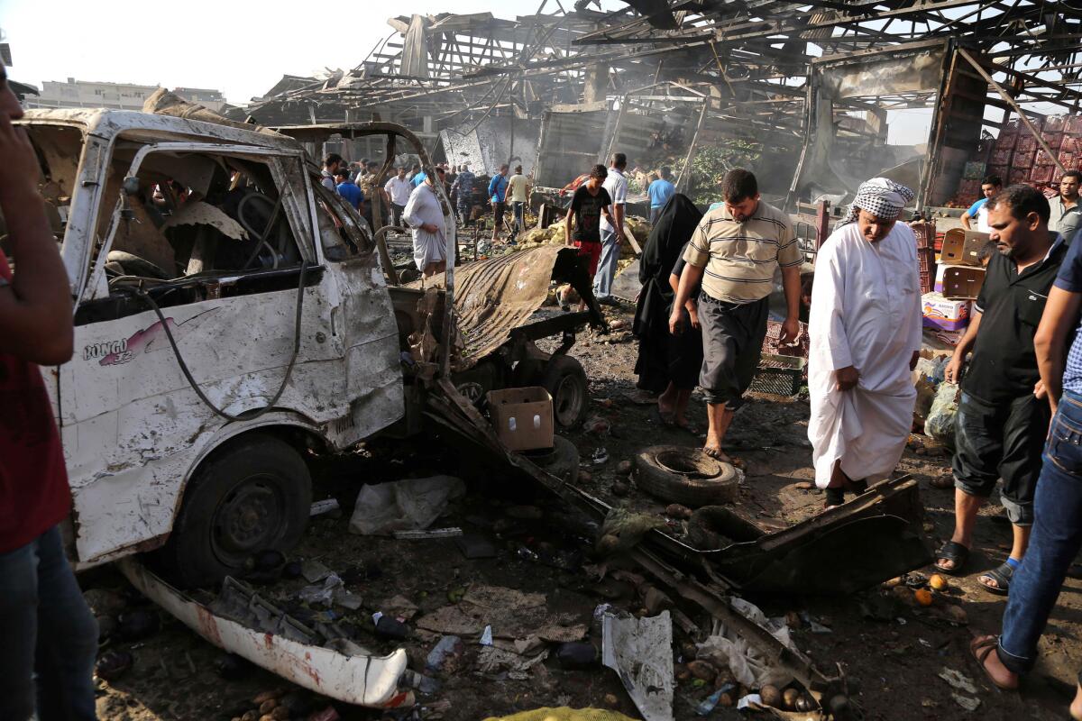 Civilians inspect the scene of an attack in the Jameela market in the crowded Sadr City neighborhood of Baghdad, where a truck bomb detonated Aug. 13.