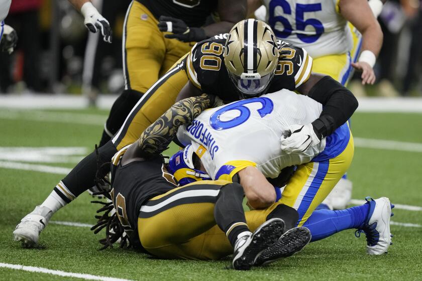 Matthew Stafford, quarterback de los Rams de Los Ángeles, es capturado por Tanoh Kpassagnon, de los Saints de Nueva Orleáns, el domingo 20 de noviembre de 2022 (AP Foto/Gerald Herbert)