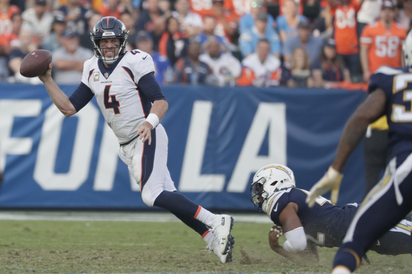 Denver Broncos quarterback Case Keenum throws an incomplete pass as he avoids a sack by Chargers linebacker Uchenna Nwoso late in the fourth quarter at Stubhub Center.