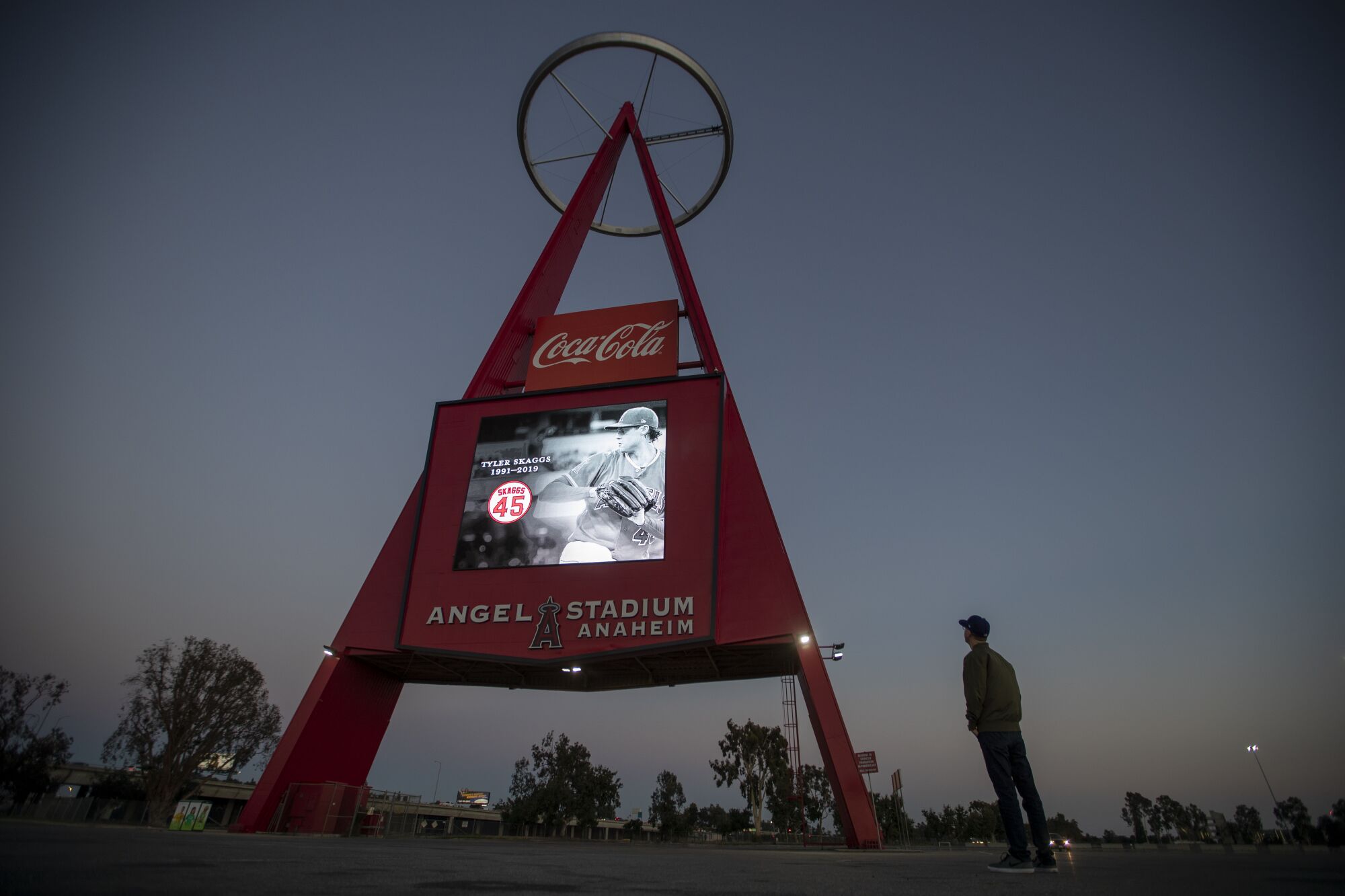 Tim McCann, of Anaheim, views a memorial to Angels pitcher Tyler Skaggs on The Big A at dusk at Angel Stadium