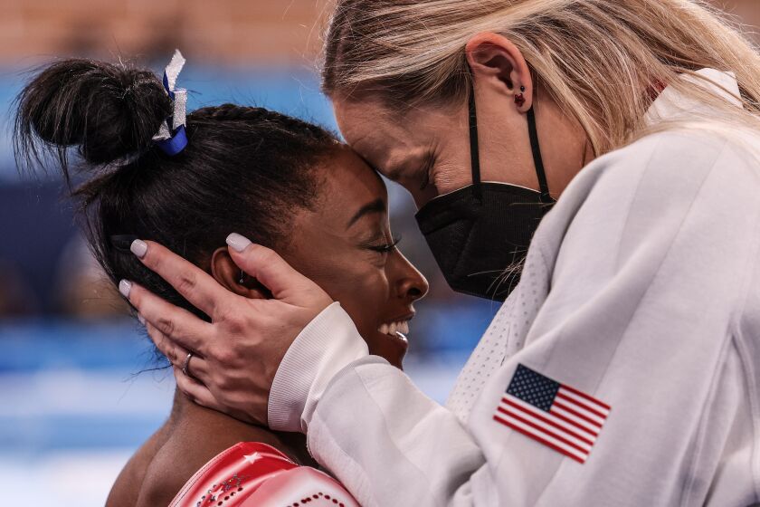 Tokyo, Japan, Tuesday, August 3, 2021 - USA gymnast Simone Biles is congratulated by her coach Cecile Landi as it becomes evident she will earn a medal in the Women's Balance Beam Final at Ariake Gymnastics Centre. (Robert Gauthier/Los Angeles Times)