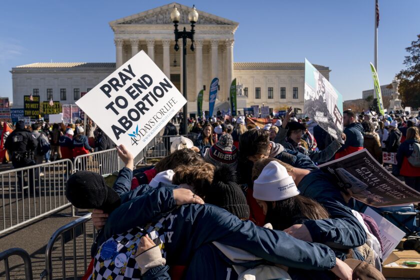 A group of anti-abortion protesters pray together in front of the U.S. Supreme Court, Wednesday, Dec. 1, 2021, in Washington, as the court hears arguments in a case from Mississippi, where a 2018 law would ban abortions after 15 weeks of pregnancy, well before viability. (AP Photo/Andrew Harnik)