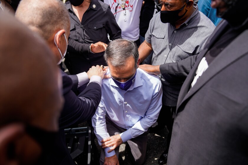 Mayor Eric Garcetti takes a knee with protesters and clergy members during a peaceful protest outside of L.A. City Hall.
