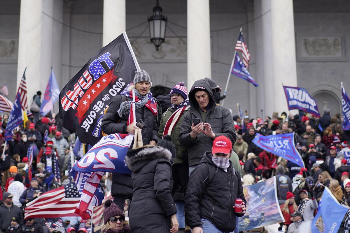 A mass of people with Trump 2020 flags and U.S. flags on the steps of the Capitol