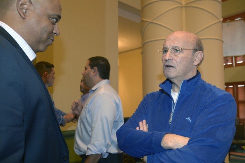 De Jon Watson, Dodgers vice president of player development, left, speaks with Dodgers president and CEO Stan Kasten during a break at baseball's winter meetings Thursday. Kasten says the team is dedicated toward not trading away its top prospects.
