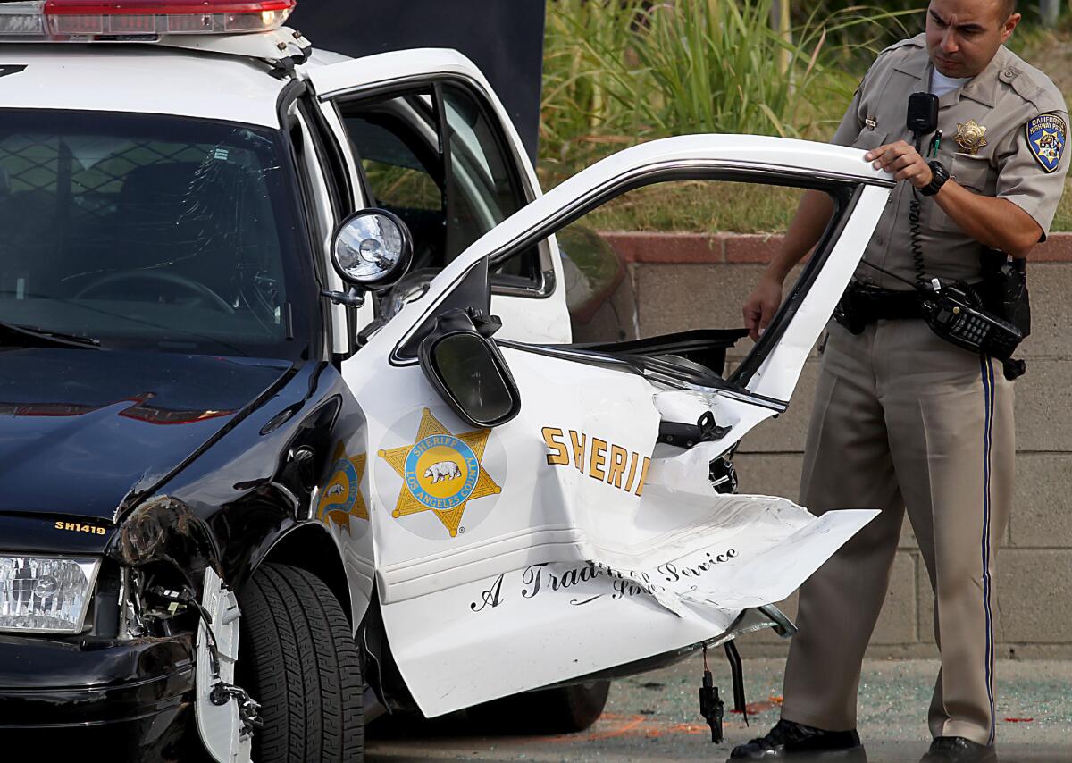 A California Highway Patrol officer looks at sheriff's patrol car that crashed during a pursuit in the 13900 block of Meyer Road in Whittier.
