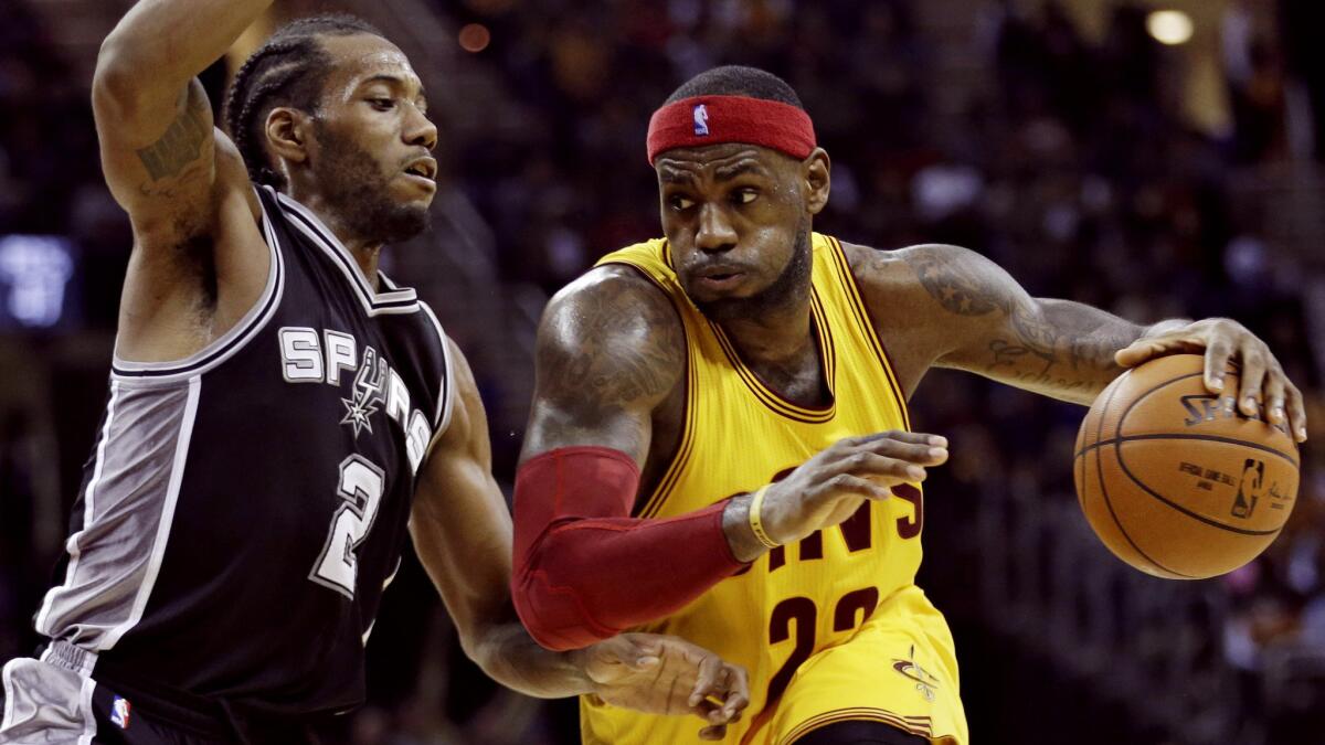 Cleveland Cavaliers' LeBron James, right, drives against San Antonio Spurs' Kawhi Leonard during the third quarter of the Spurs' 92-90 win Wednesday.