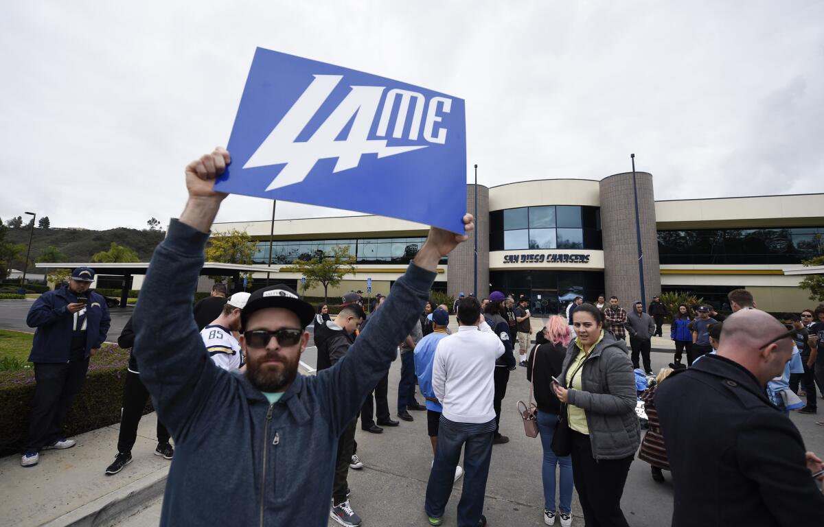 A San Diego Chargers fan holds up a sign in front of Chargers headquarters after the team announced that it will move to Los Angeles.