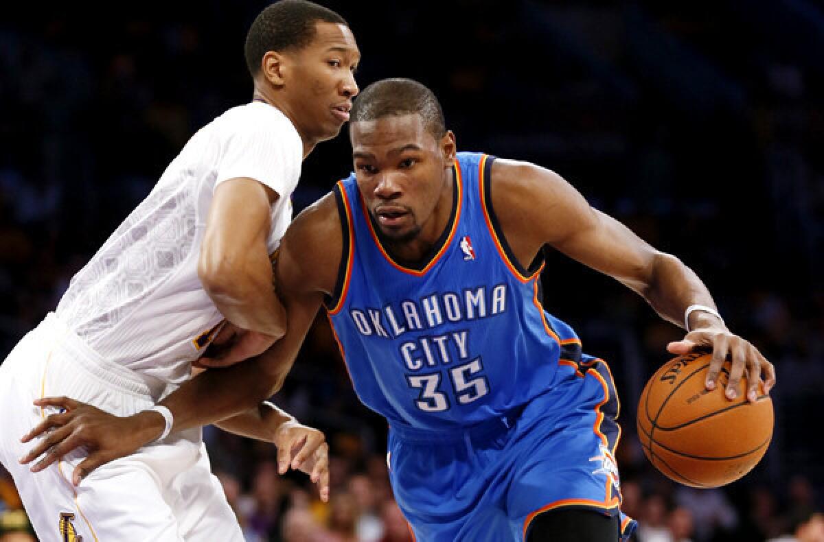 Thunder forward Kevin Durant drives against Lakers forward Wesley Johnson in the first half Sunday at Staples Center.