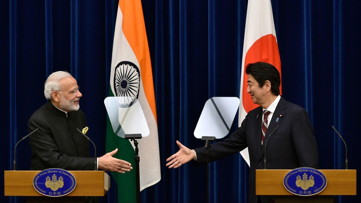 Indian Prime Minister Narendra Modi, left, and Japanese Prime Minister Shinzo Abe shake hands during a joint press conference at Abe's official residence in Tokyo on Friday.
