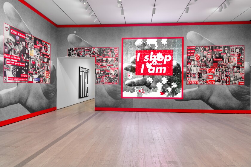 A gallery covered in wallpaper shows large human hands holding collages of images inspired by Barbara Kruger's work 