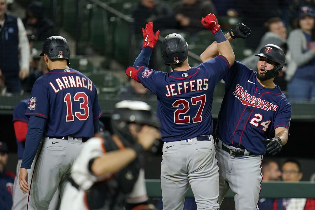 Minnesota Twins' Ryan Jeffers (27) is greeted near home plate by Gary Sanchez (24) after Jeffers scored Sanchez, Trevor Larnach (13) and himself on three-run home run against the Baltimore Orioles during the sixth inning of a baseball game, Tuesday, May 3, 2022, in Baltimore. (AP Photo/Julio Cortez)