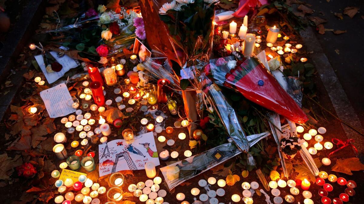 People pay tribute to those who died in the Nov. 13, 2015 Paris attacks at the Bataclan Theatre.