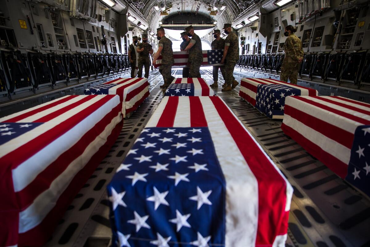 U.S. Marines carry a casket inside a U.S. Air Force C-17 Globemaster III at Marine Corps Air Station Miramar